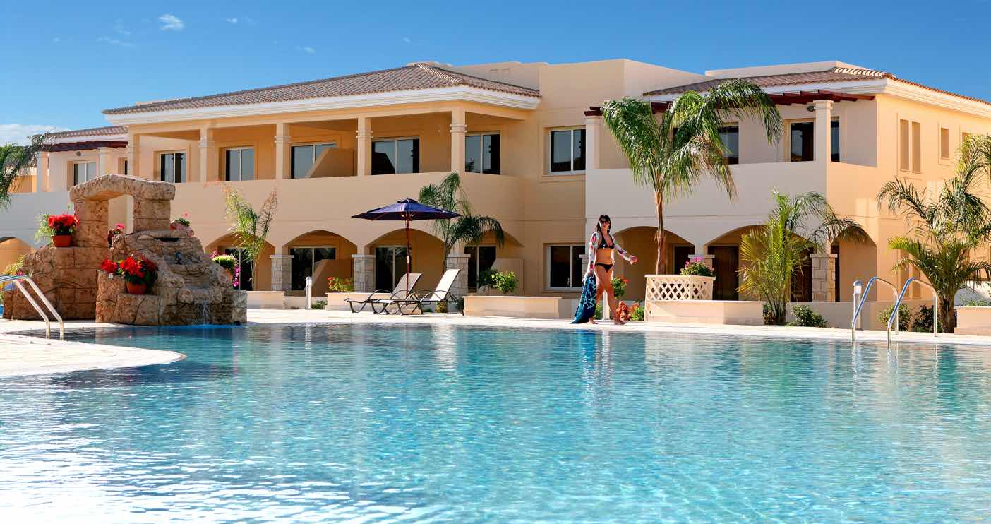 Walking by the swimming pool at Paphos Aphrodite Sands Resort Paphos Aphrodite Sands Resort Guest walking by the swimming pool